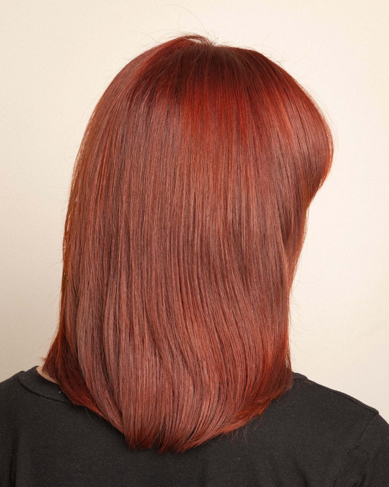 model volledig: "Achterkant model met haar volledig gekleurd met Green Heads Rood – krachtige rode tint"